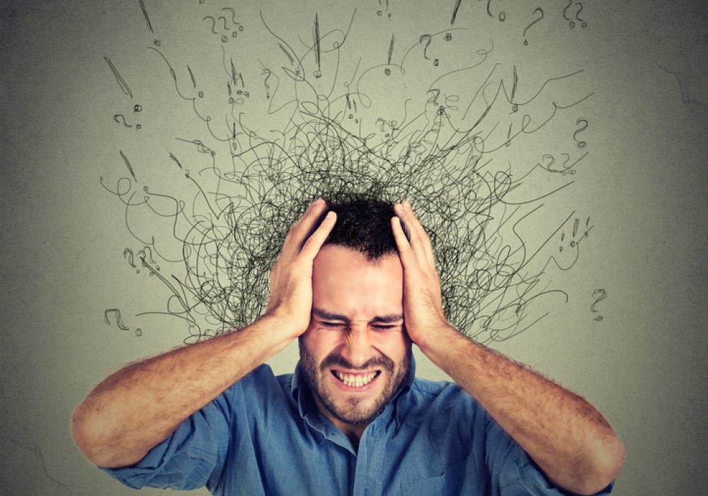 Stressed man upset frustrated has too many thoughts with brain melting into lines question marks. Obsessive compulsive, adhd, anxiety disorder. Negative human emotions face expression feelings